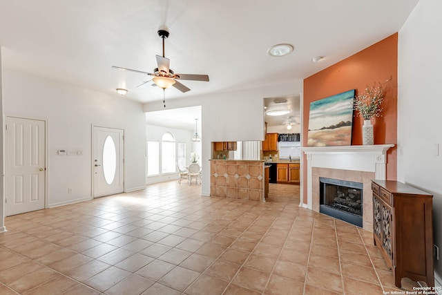 living area with ceiling fan, light tile patterned floors, a tile fireplace, and baseboards