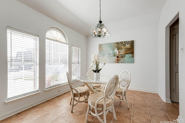 dining area with light tile patterned floors, an inviting chandelier, and baseboards