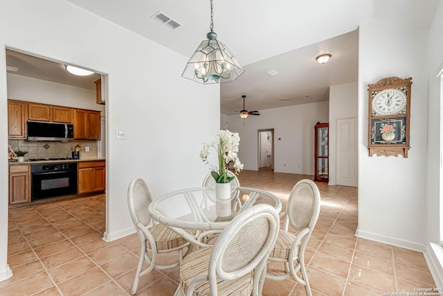 dining area featuring light tile patterned floors, baseboards, visible vents, and a ceiling fan