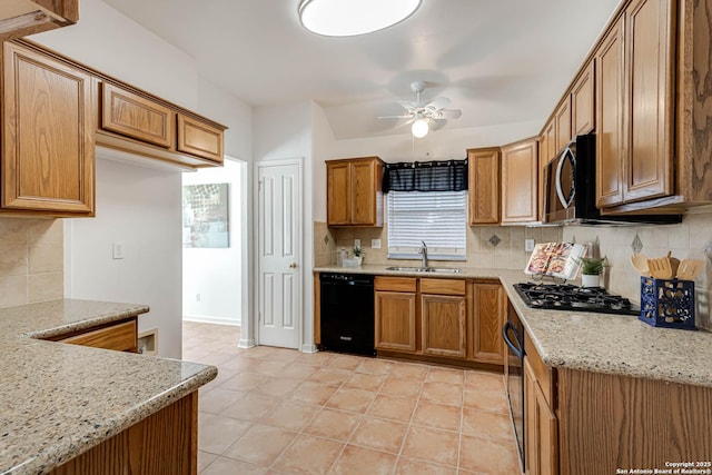 kitchen with a sink, a ceiling fan, backsplash, black appliances, and brown cabinetry