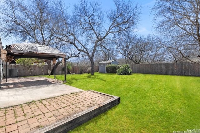 view of yard with an outbuilding, a fenced backyard, a patio, and a gazebo