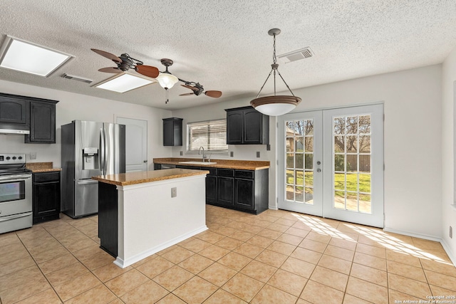 kitchen with light tile patterned flooring, stainless steel appliances, a sink, visible vents, and french doors