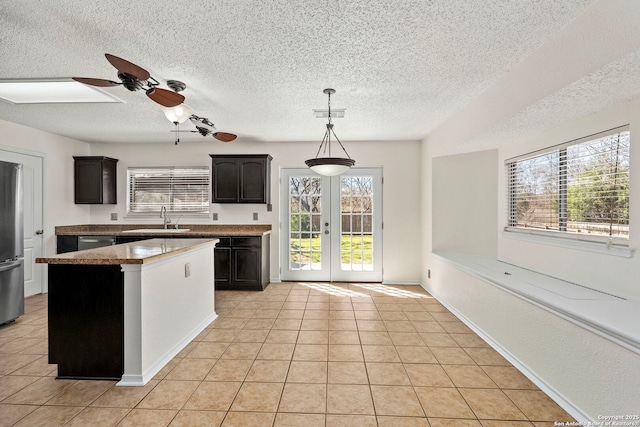 kitchen with french doors, light tile patterned floors, stainless steel appliances, visible vents, and a sink