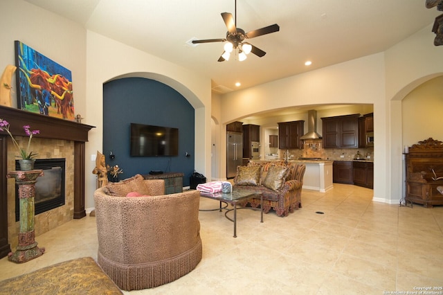 living area with a ceiling fan, a tile fireplace, light tile patterned floors, and recessed lighting