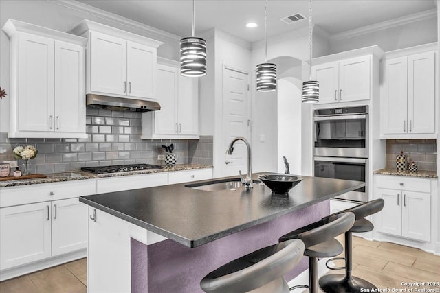 kitchen with visible vents, appliances with stainless steel finishes, ornamental molding, a sink, and under cabinet range hood