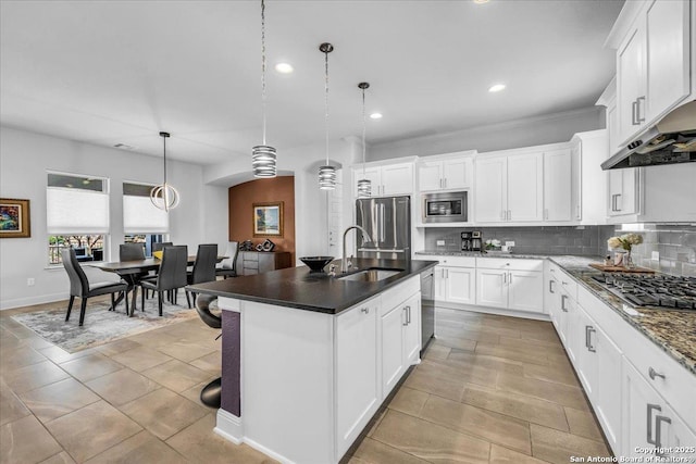 kitchen featuring appliances with stainless steel finishes, white cabinets, and backsplash