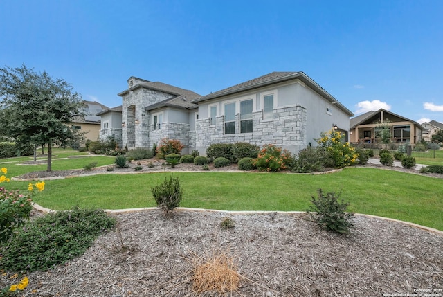 view of front facade with stone siding, a front lawn, and stucco siding