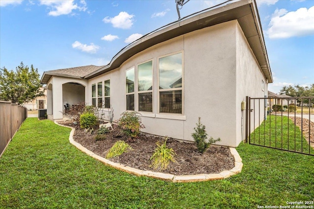 view of property exterior featuring central air condition unit, a yard, fence, and stucco siding