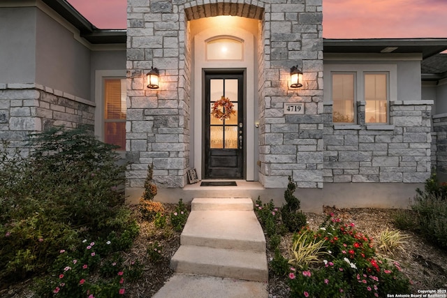 property entrance with stone siding and stucco siding