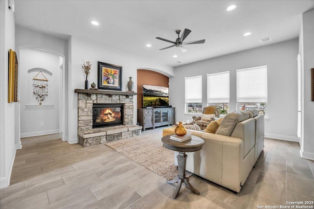 living room with baseboards, visible vents, a ceiling fan, a fireplace, and recessed lighting