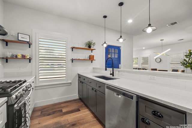 kitchen featuring open shelves, appliances with stainless steel finishes, dark wood-type flooring, and a sink