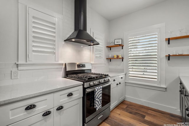 kitchen with tasteful backsplash, dark wood-style floors, wall chimney range hood, open shelves, and stainless steel range with gas stovetop