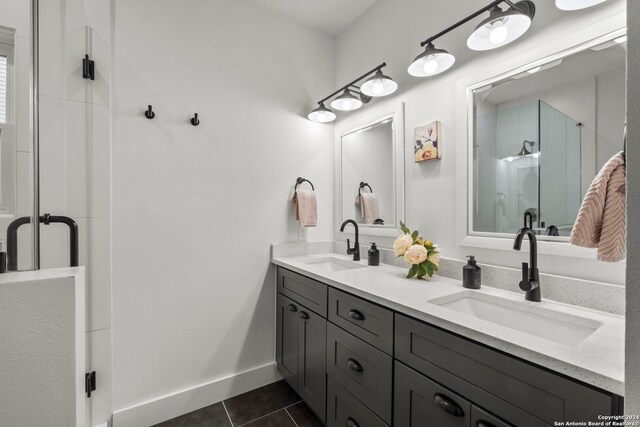 bathroom featuring double vanity, tile patterned flooring, a sink, and a shower stall