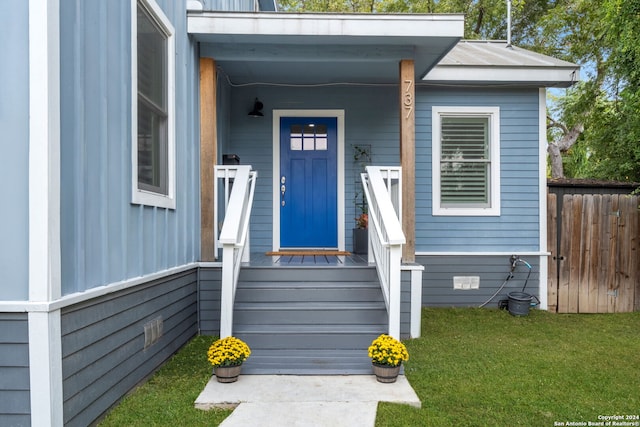 doorway to property with crawl space, fence, and a lawn