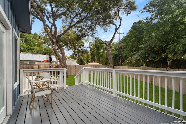 deck with a fenced backyard and a yard