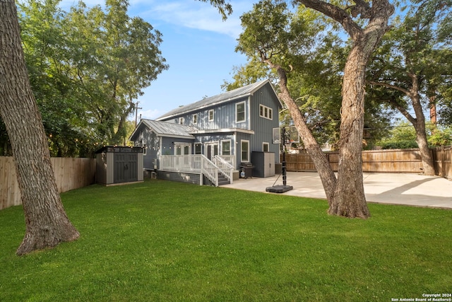 rear view of property with a storage shed, a fenced backyard, a yard, a patio area, and an outdoor structure