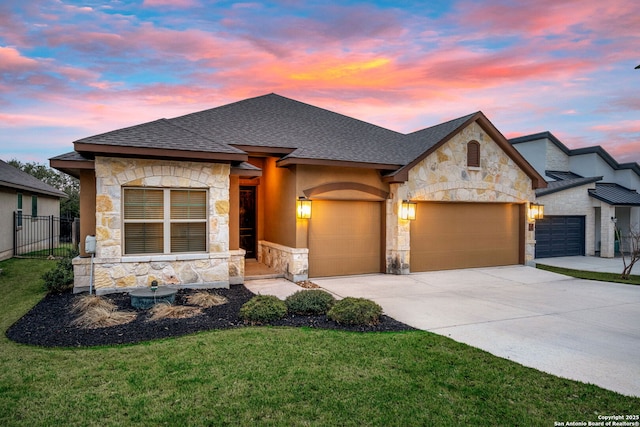 french country style house with stone siding, an attached garage, concrete driveway, and roof with shingles