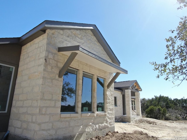 view of side of property with stone siding