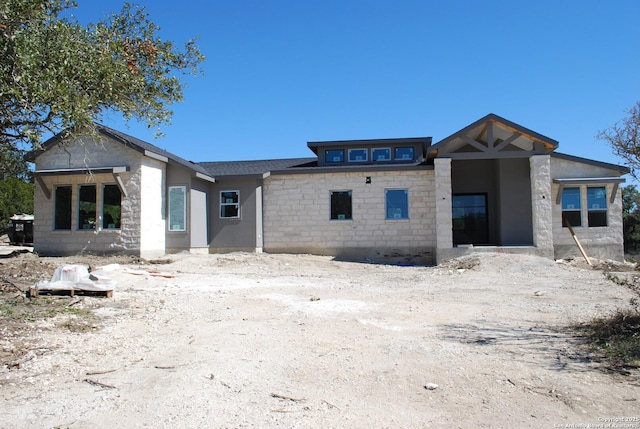 back of property featuring stone siding