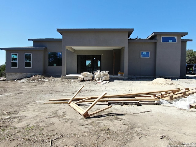 back of property featuring stucco siding