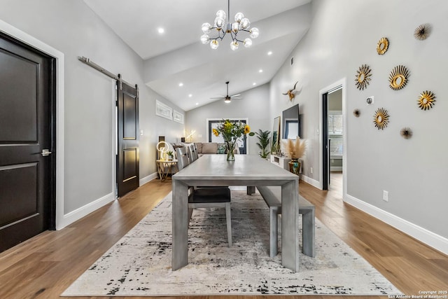 dining room with a barn door, baseboards, wood finished floors, ceiling fan with notable chandelier, and recessed lighting