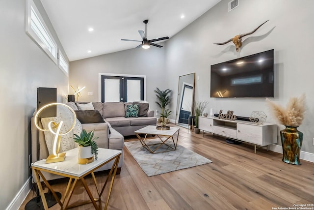 living area featuring visible vents, ceiling fan, wood finished floors, high vaulted ceiling, and baseboards