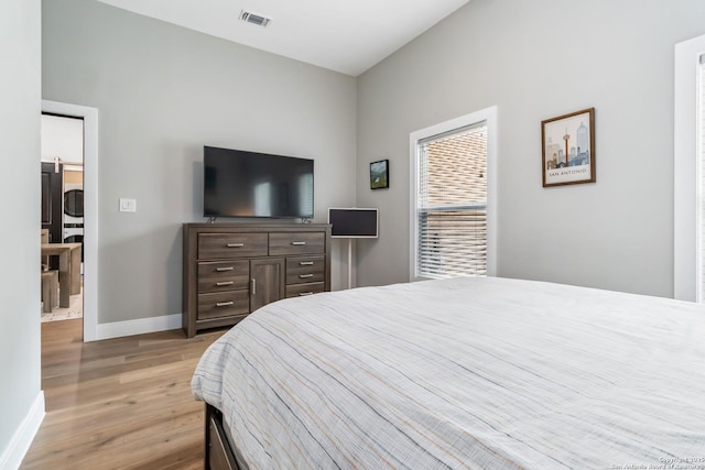 bedroom featuring light wood finished floors, baseboards, and visible vents