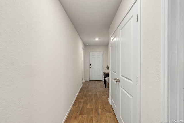 hallway featuring dark wood-style floors and baseboards