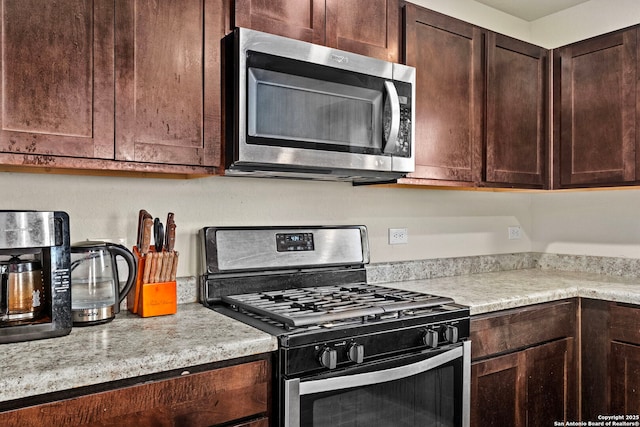 kitchen with appliances with stainless steel finishes, light countertops, and dark brown cabinets