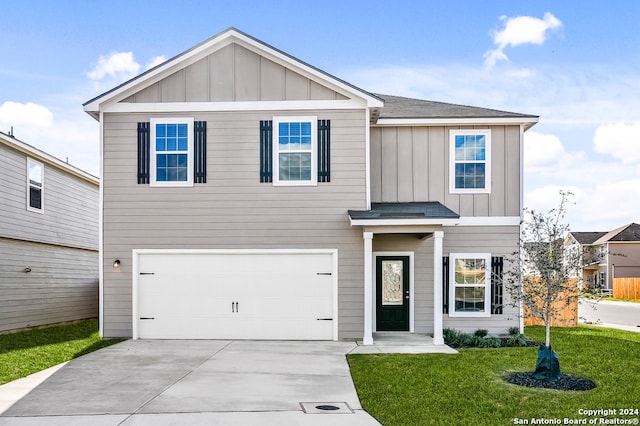 view of front of house featuring a garage, concrete driveway, a front lawn, and board and batten siding