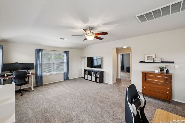 carpeted home office featuring baseboards, visible vents, arched walkways, a ceiling fan, and lofted ceiling