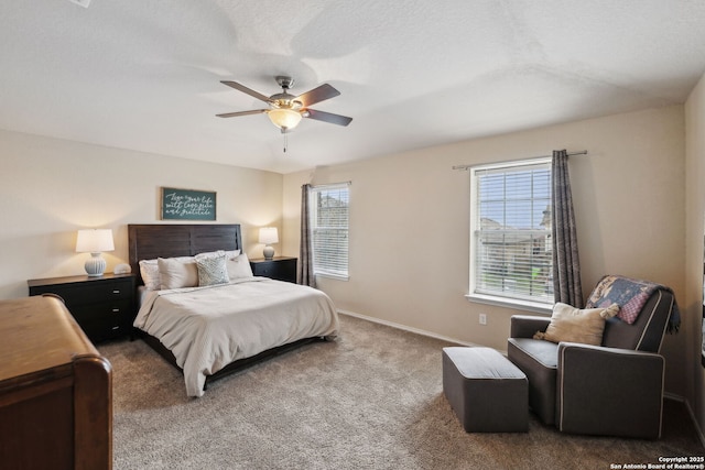 carpeted bedroom featuring a textured ceiling, a ceiling fan, and baseboards