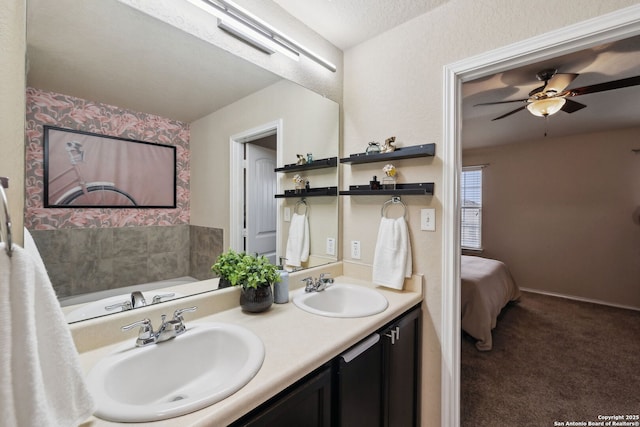 ensuite bathroom with ensuite bathroom, double vanity, ceiling fan, and a sink