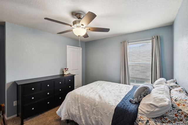 bedroom with a textured ceiling, carpet floors, and a ceiling fan