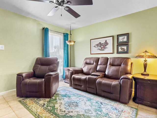 tiled living area with baseboards and a ceiling fan