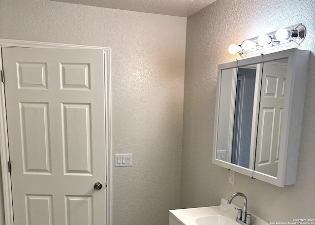 bathroom with vanity and a textured wall