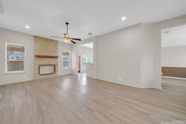 unfurnished living room featuring a large fireplace, visible vents, light wood finished floors, and crown molding