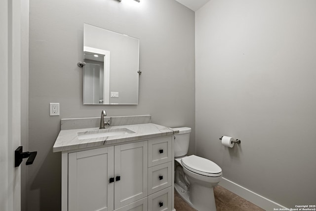 bathroom featuring tile patterned flooring, vanity, toilet, and baseboards