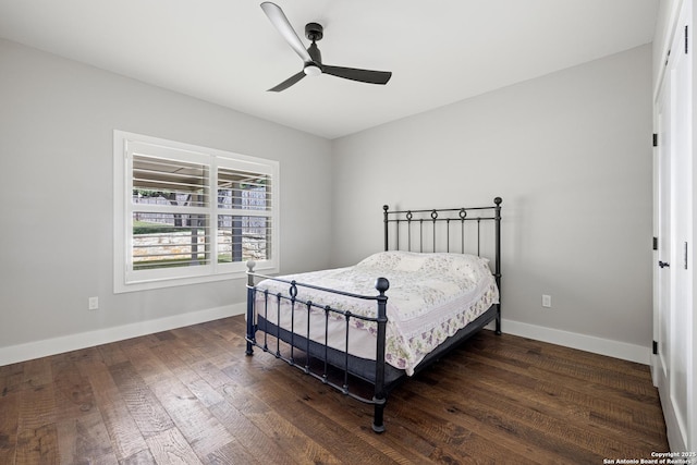 bedroom with a ceiling fan, hardwood / wood-style flooring, and baseboards