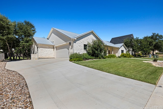 view of side of property with a lawn, metal roof, a garage, stone siding, and driveway