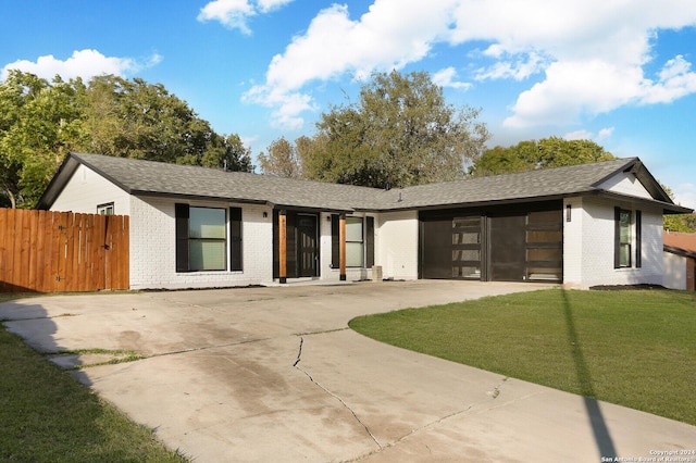 view of front of house with a garage, driveway, a front yard, and brick siding