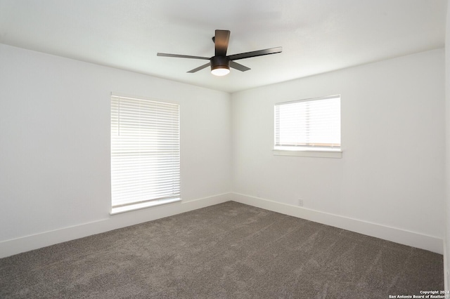 empty room with ceiling fan, baseboards, and dark colored carpet