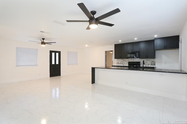 kitchen featuring tasteful backsplash, dark countertops, dark cabinets, marble finish floor, and black appliances