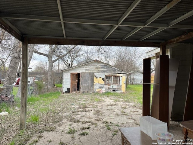 view of yard featuring a carport, an outbuilding, and fence