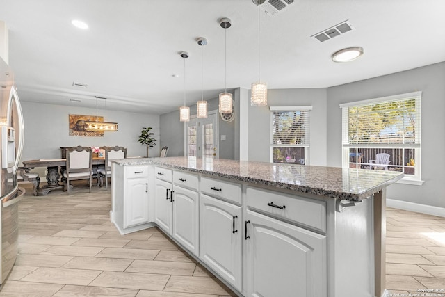 kitchen featuring decorative light fixtures, wood finish floors, visible vents, and white cabinetry