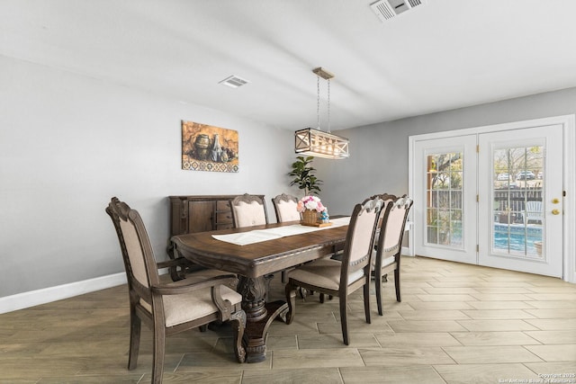 dining area with light wood-style floors, visible vents, and baseboards