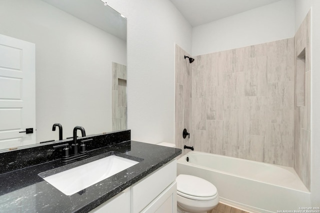 bathroom featuring washtub / shower combination, vanity, and toilet