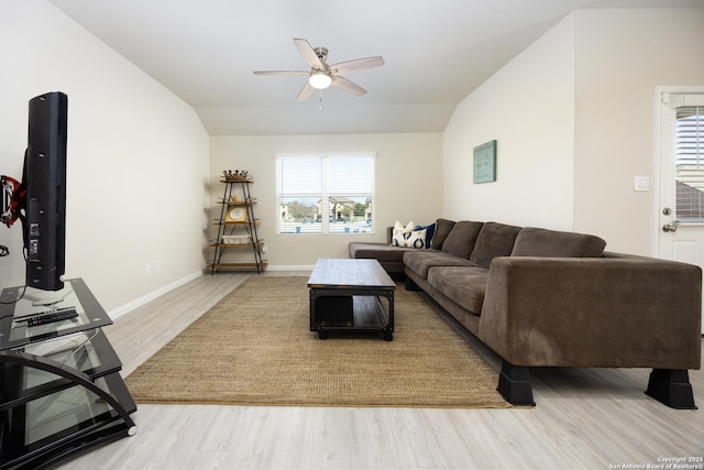 living area featuring lofted ceiling, ceiling fan, light wood-type flooring, and baseboards