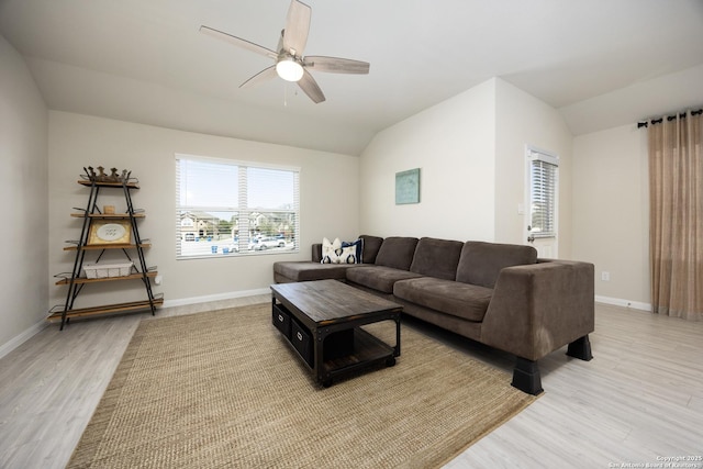 living area with light wood-type flooring, ceiling fan, baseboards, and vaulted ceiling