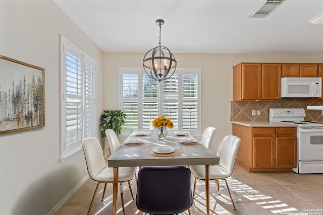 dining space featuring a chandelier, light tile patterned floors, visible vents, and baseboards